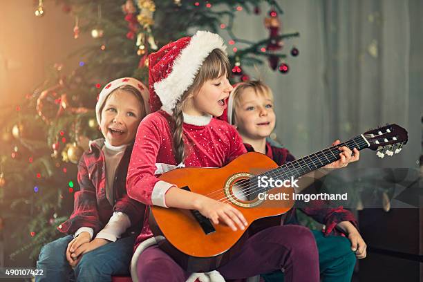 Niños Canta Carols Cerca Del Árbol De Navidad Foto de stock y más banco de  imágenes de Navidad - Navidad, Villancicos, Cantar - iStock