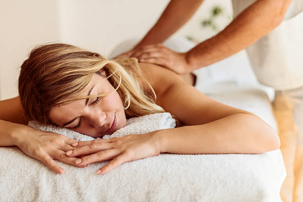 tratamento da sua pele - massaging massage therapist rear view human hand imagens e fotografias de stock