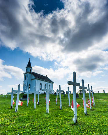 A cemetery in New Brunswick. The crosses and flags, on the grounds of a small white church, are for Canadian soldiers who were killed during the 2nd world war.