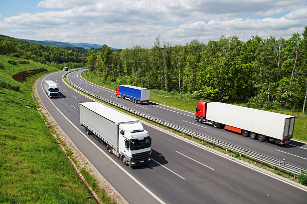 istock Trucks traveling on an asphalt highway between forests. 490127614
