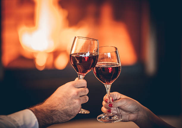 istock Glasses of red wine and romantic fireplace 490129690
