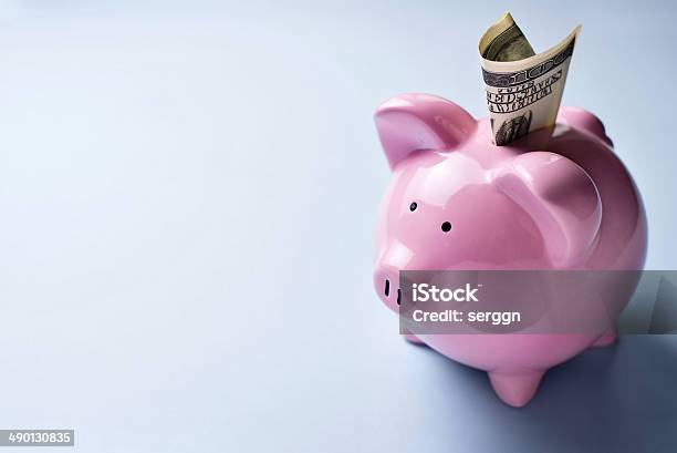 Pink Piggy Bank With A Dollar Bill In The Slot Stock Photo - Download Image Now - Aspirations, Coin Bank, Concepts