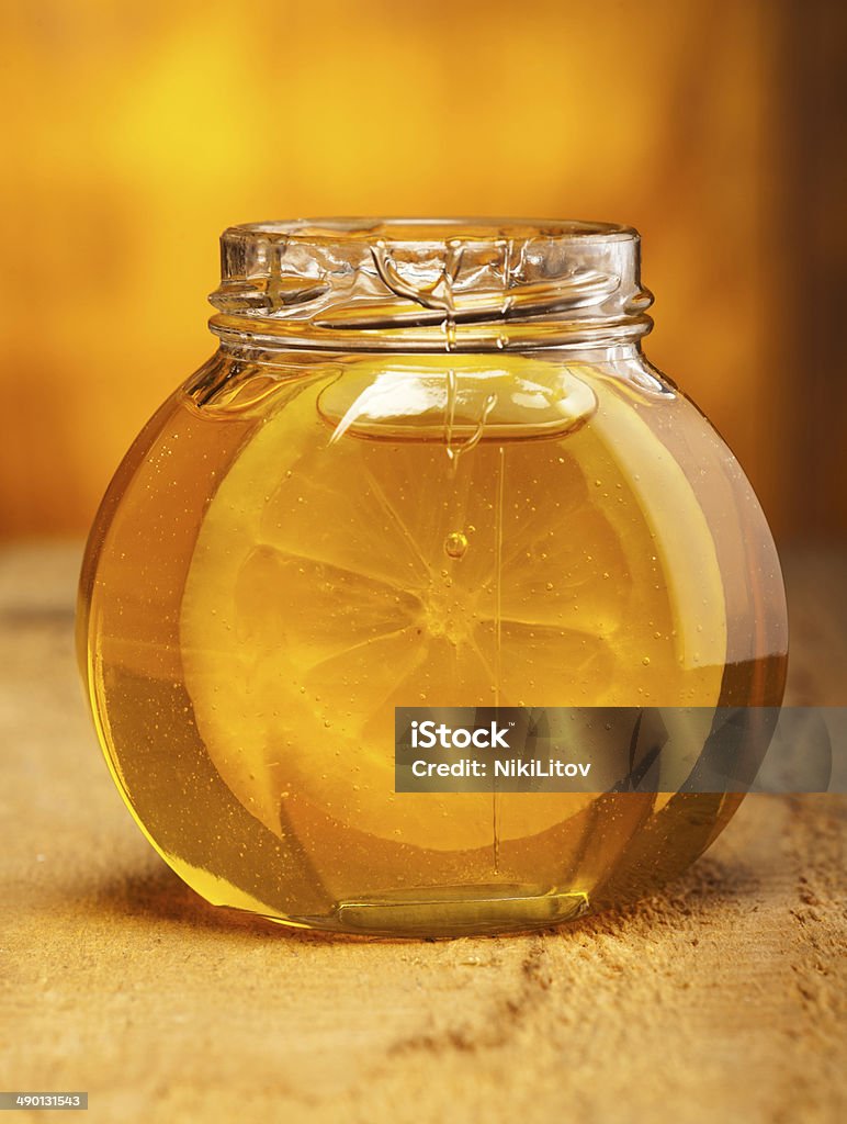 Honey Glass jar of honey with slice of lemon on old wooden background. Backgrounds Stock Photo
