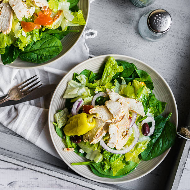 istock Green chicken salad on wooden background 490132130