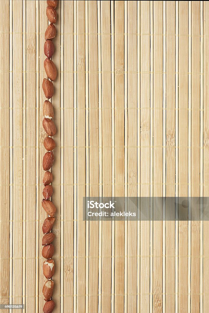 Cases a band of peanut lying on bamboo mat Cases a band of peanut lying on bamboo mat, as background Backgrounds Stock Photo