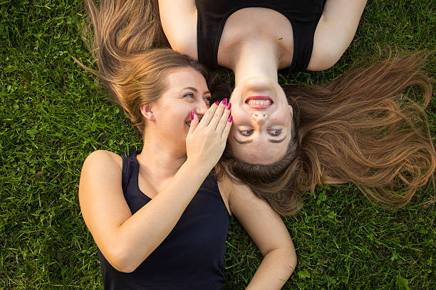 istock Two girls, making funny faces. Laying in green grass 490135816
