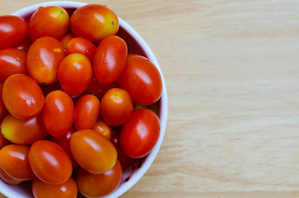 istock Red Cherry Tomatoes In White Ceramic Bowl On Wood Table. 490141036