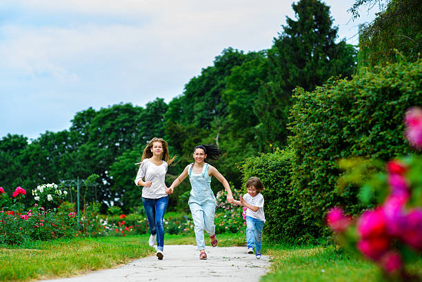 istock Happy Mother with daughter and son running on grass smiling 490141532