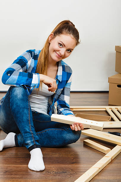 Woman assembling wooden furniture. DIY.
