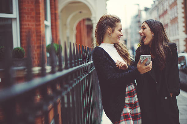 Fancy women in London using a mobile phone