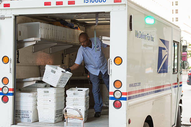 USPS Chicago, USA - September 10, 2015: A USPS deliveryman sorting in the back of his truck on LaSalle street in the Loop late in the day. united states postal service photos stock pictures, royalty-free photos & images