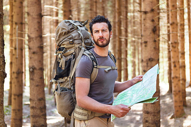 человек с рюкзак и карта поиск направления - discovery forest lost confusion стоковые фото и изображения