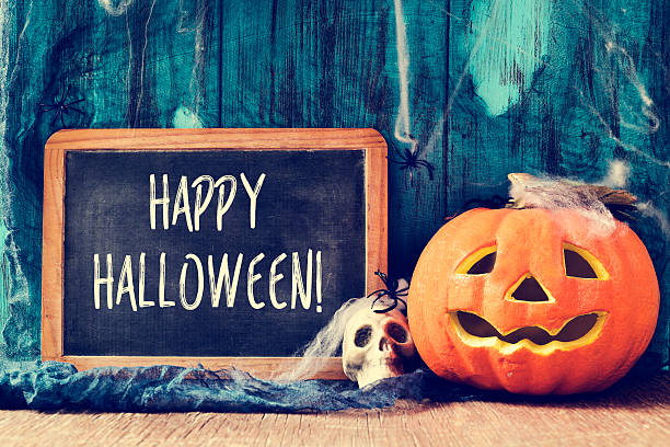 istock skull, jack-o-lantern and text happy halloween in a chalkboard 490180664