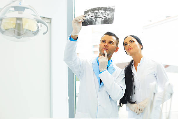 istock Dentist and female assistant are discussing dental X Ray image 490181538