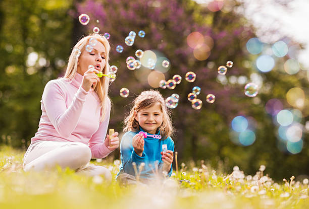 istock Mother and daughter blowing bubbles in nature. 490182872