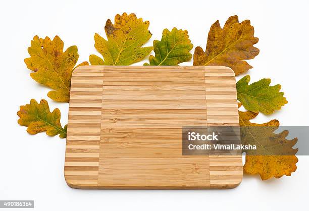 Autumn Oak Leaves And Kitchen Wooden Cutting Board Top View Stock Photo - Download Image Now