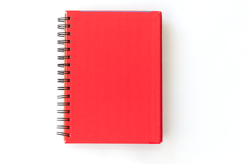 Cuaderno con espiral roja sobre fondo blanco photo