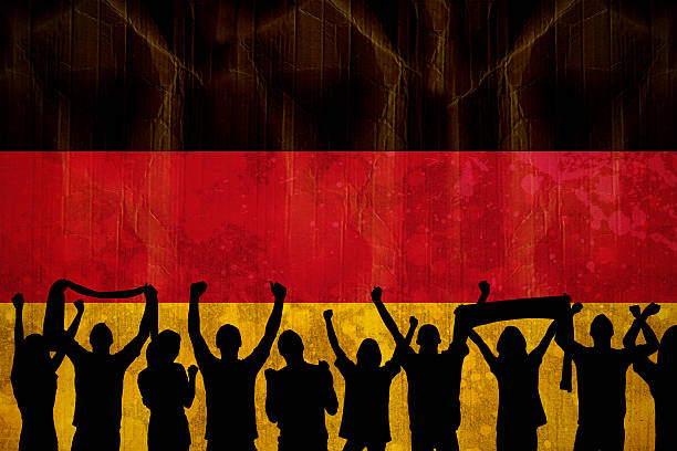 Silhouettes of football supporters against germany flag in grunge effect