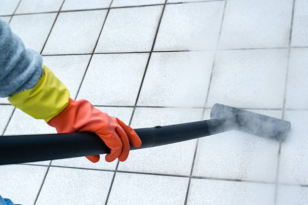 Woman using steam cleaner Woman wearing rubber gloves using steam cleaner to brighten up balcony tiles steam cleaning stock pictures, royalty-free photos & images