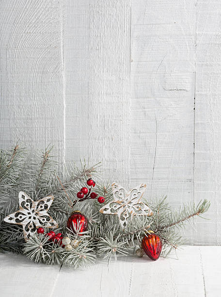 Fir branch with Christmas decorations on the wooden plank