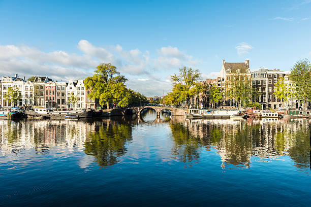 amstel канал домов в амстердаме, нидерланды - amsterdam стоковые фото и изображения