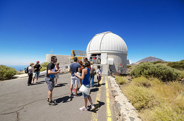 Tourist visiting a telescope in Teide astronomical Observatory Tenerife, Spain - July 7, 2015: Tourist visiting a telescope on July 7, 2015 in Teide astronomical Observatory, Tenerife, Canary Island, Spain. observatory tenerife canary islands el teide national park stock pictures, royalty-free photos & images