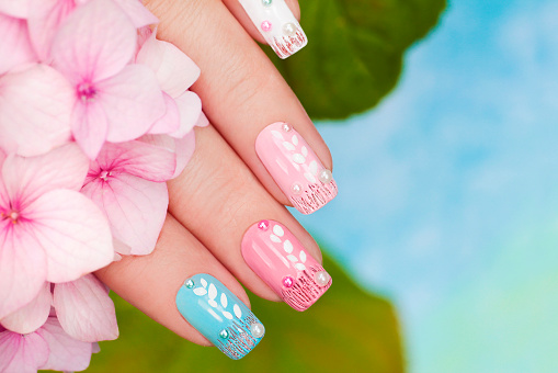 Pastel manicure with rhinestones and sequins on the background of Hydrangeas.
