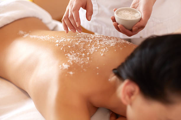 spa frau. brunette immer eine salt scrub beauty behandlung - massaging spa treatment health spa women stock-fotos und bilder