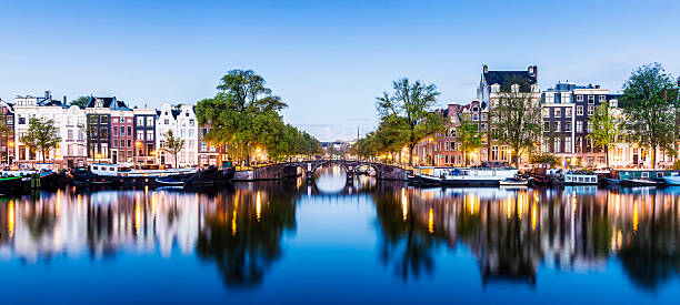 Bridges and Canals of Amsterdam Illuminated at Sunset Holland Bridge and canal houses in Amsterdam at twilight, Holland. canal house photos stock pictures, royalty-free photos & images