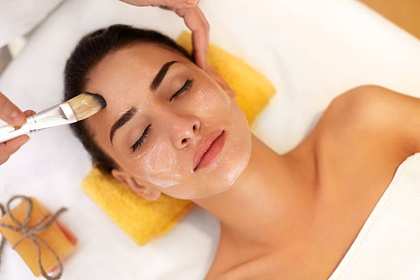 soin du visage. femme dans un salon de beauté est un masque marin - facial mask spa treatment health spa human face photos et images de collection