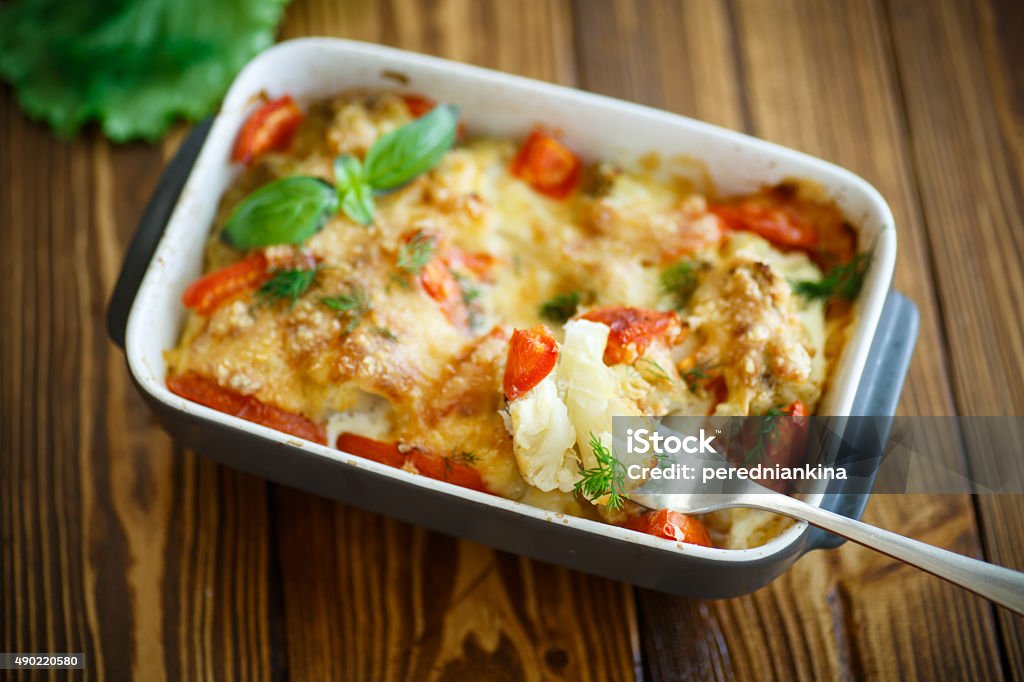 Cauliflower baked with  tomatoes Cauliflower baked with eggs, tomatoes, vegetables and cheese Gratin Stock Photo