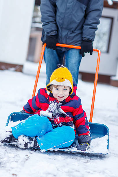 istock Funny kid boy having fun with riding on snow shovel 490221954