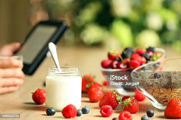 Person Using Tablet Over Healthy Breakfast Stock Photo - Download Image Now - 2015, Berry, Berry Fruit