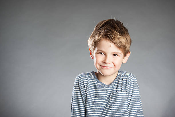 istock Portrait of boy, emotion, smiling, grey background 490238438