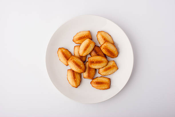 Madeleine cookies on the ceramic plate on the white background stock photo