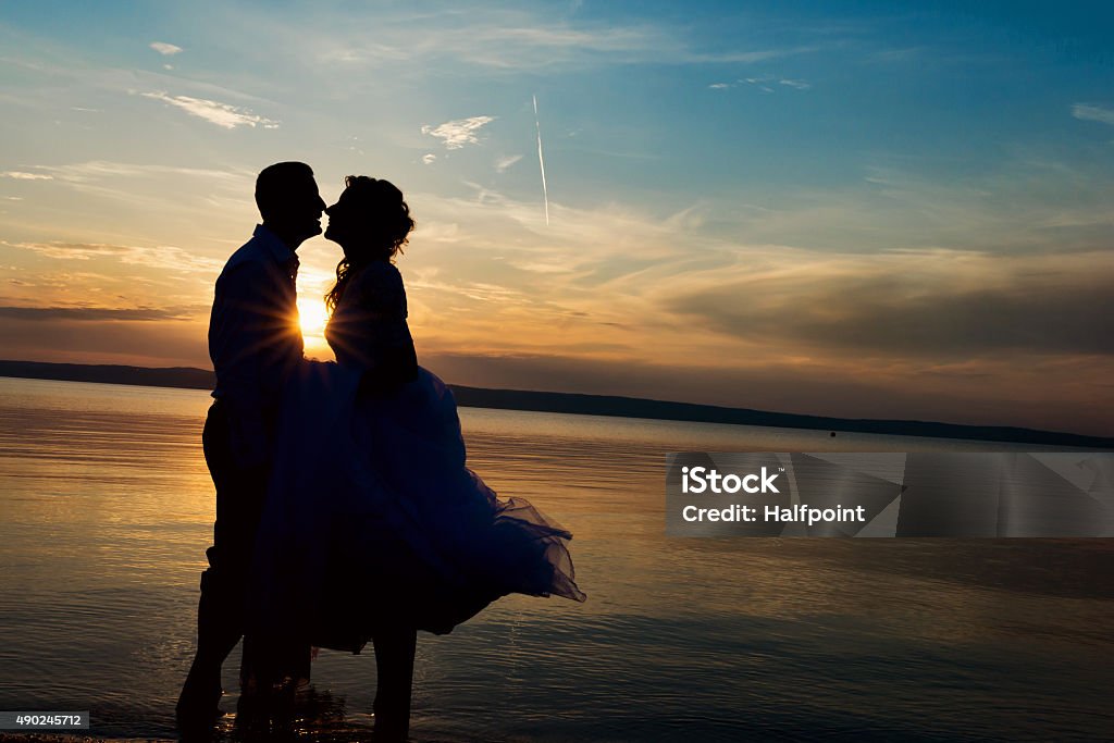 Beautiful wedding couple Beautiful young wedding couple standing on the beach Lake Stock Photo