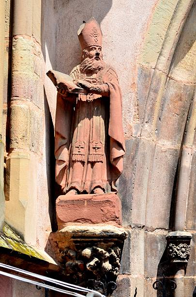 Statue of the St. Augustine, from the 18th century. It stands at the left side of the main door of the Church of the Augustinians, in the old Town of Ribeauville, France. Located between the Vosgues mountains and the Rhine valley, Ribeauville is one of the many towns which integrate the Alsatian wine road.