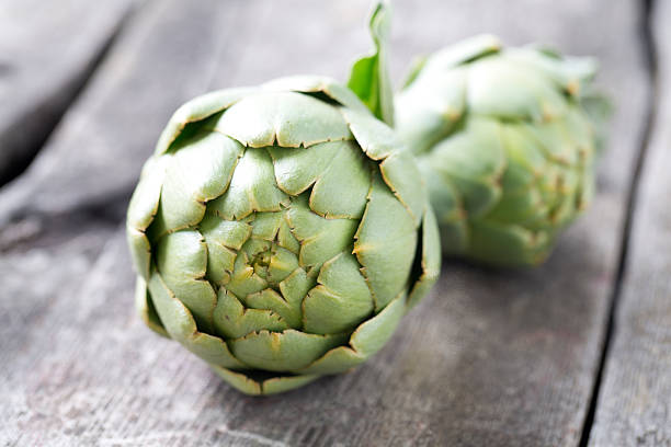 istock artichokes on wooden surface 490246428