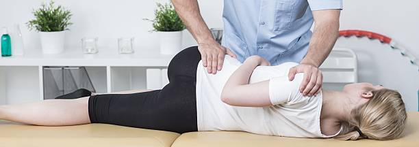 Chiropractic examining patient Young woman lying in the table at medical office chiropractor photos stock pictures, royalty-free photos & images