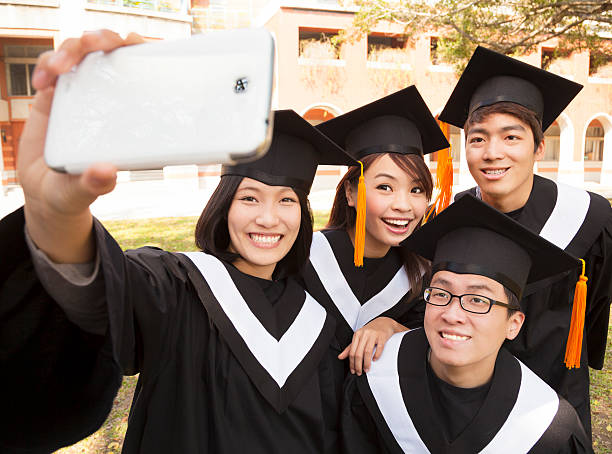 istock group of graduates  taking picture with cell phone 490260061
