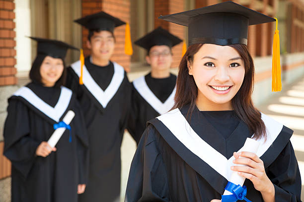 istock beautiful  college graduate holding diploma with classmates 490260215