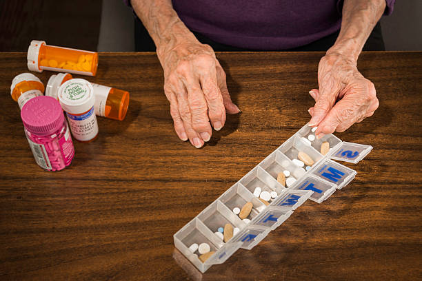 istock Senior arthritis hands putting pills in 7-Day pill organizer 490264367