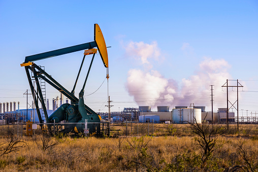 A pumpjack (oil derrick) and oil refinery in Seminole, West Texas.