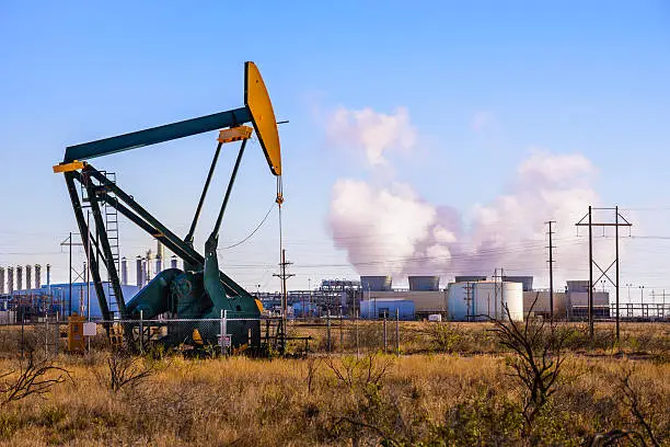 A pumpjack (oil derrick) and oil refinery in Seminole, West Texas.