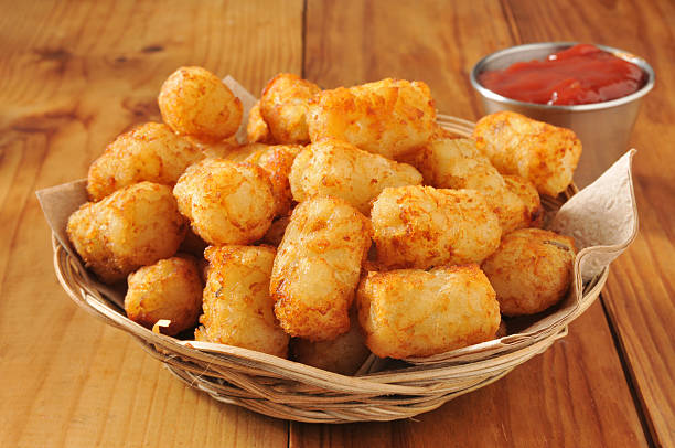 Tater tots and catsup A basket of tater tots on a rustic wooden counter Tater Tots stock pictures, royalty-free photos & images