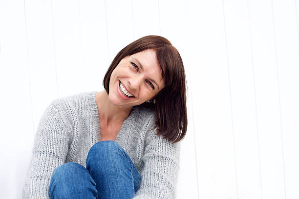 istock Smiling middle aged woman sitting against white wall 490275242