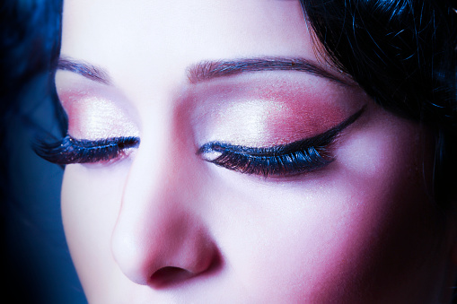 Closeup macro shot of  human female eye. Woman with natural evening vogue face beauty makeup. Girl with perfect skin and aquamarine eyes shadows
