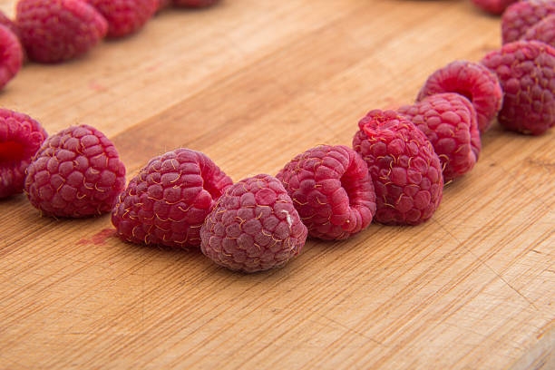 istock Ripe sweet raspberries on wood table close-up 490285786