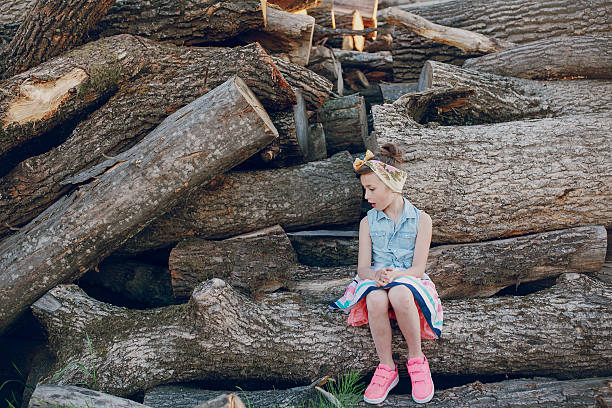 istock beautiful little girl sitting on trees 490288652