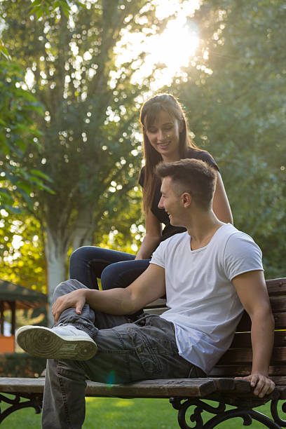 istock Brother and sister, sitting on bench at park. young 490305774